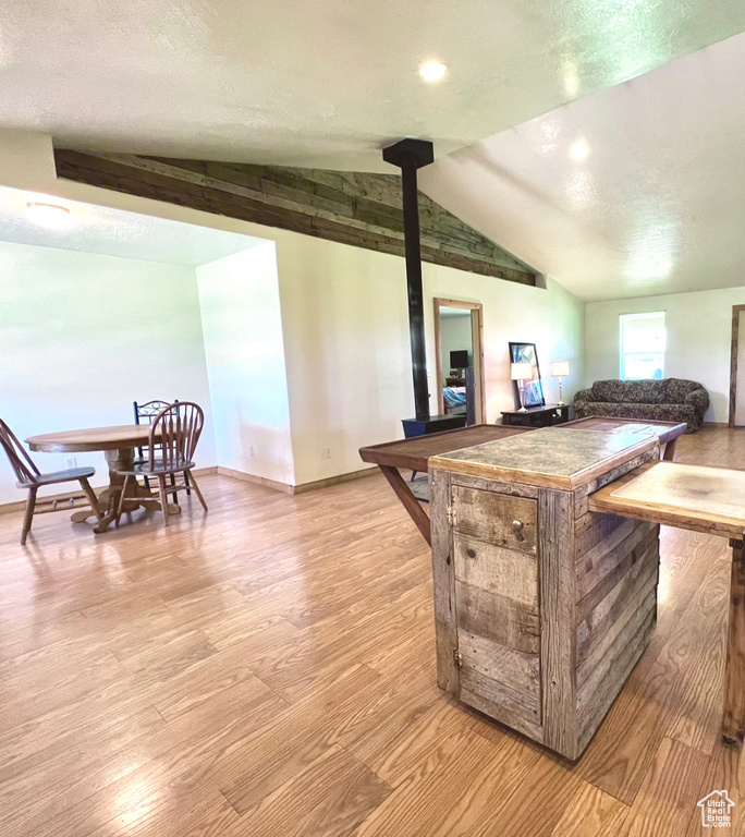 Bar featuring lofted ceiling, light wood-type flooring, and a textured ceiling