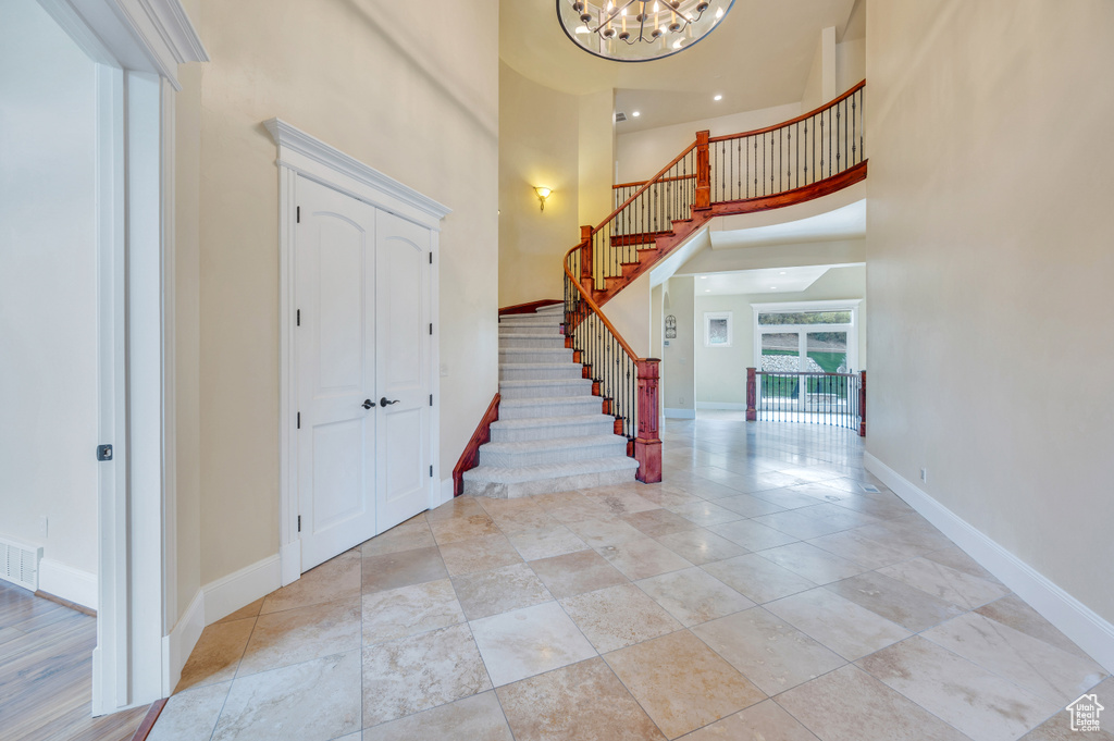 Entryway featuring a towering ceiling and an inviting chandelier