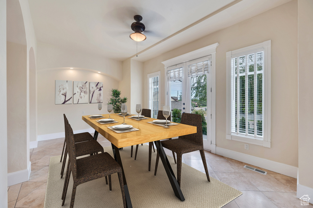 Tiled dining space featuring ceiling fan and french doors