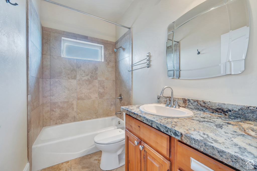 Full bathroom with tile patterned flooring, vanity, toilet, and tiled shower / bath