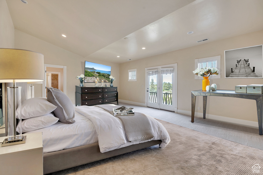 Carpeted bedroom with access to exterior and vaulted ceiling