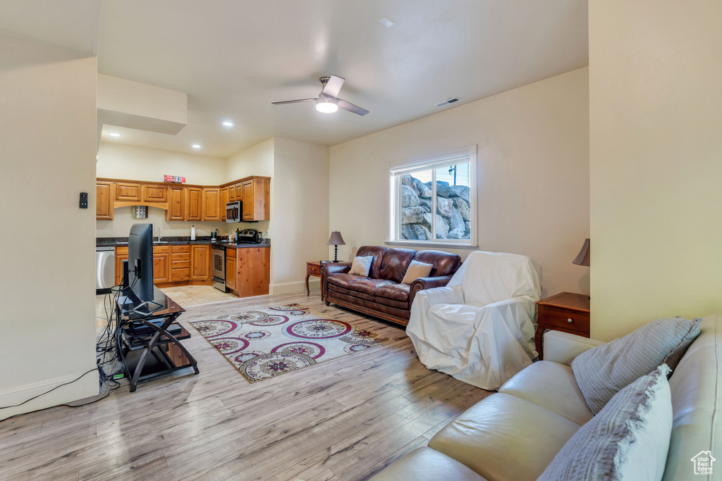 Living room featuring ceiling fan and light wood-type flooring