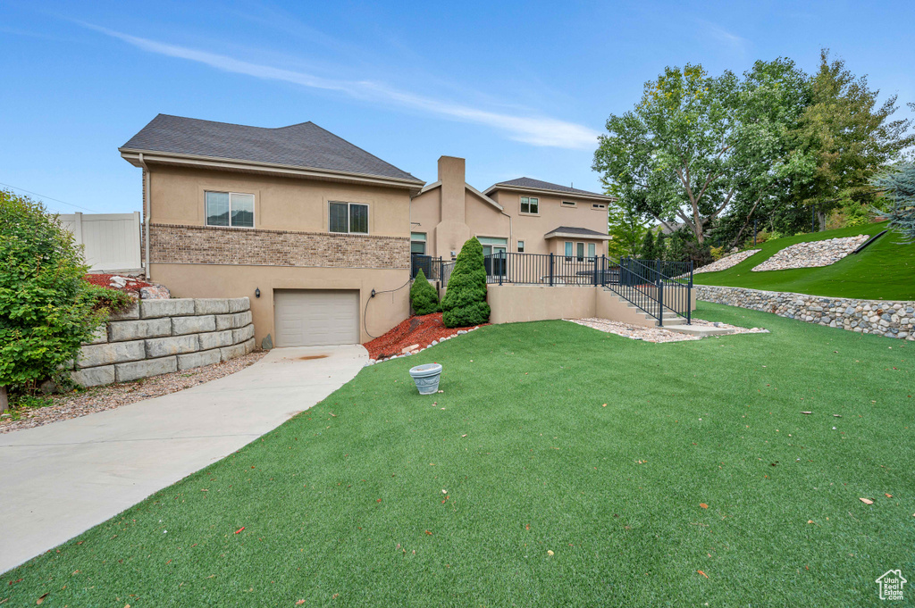 View of front of property featuring a front yard and a garage