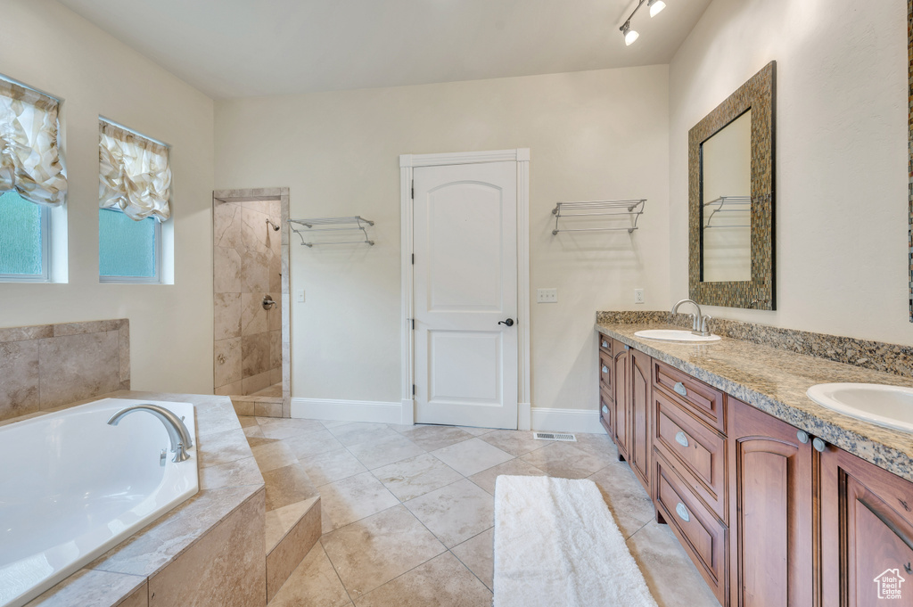 Bathroom featuring vanity and separate shower and tub