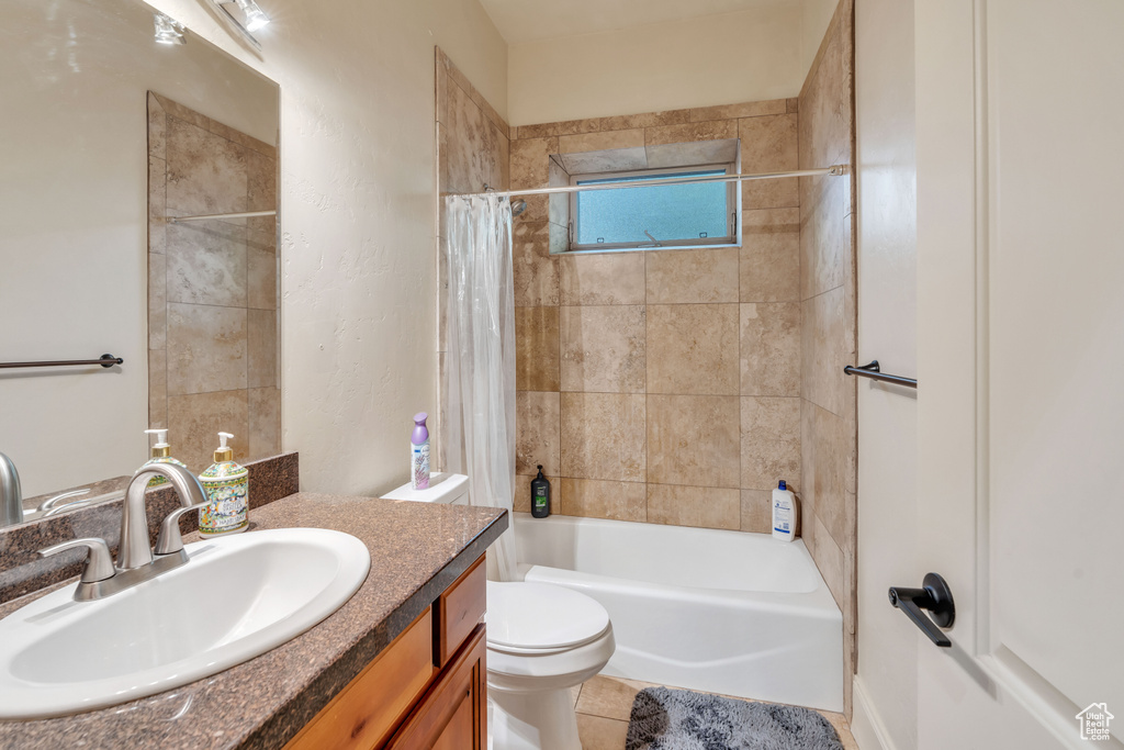 Full bathroom with tile patterned flooring, shower / tub combo with curtain, vanity, and toilet