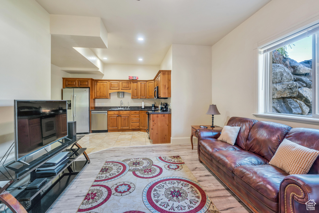 Living room with light wood-type flooring and sink