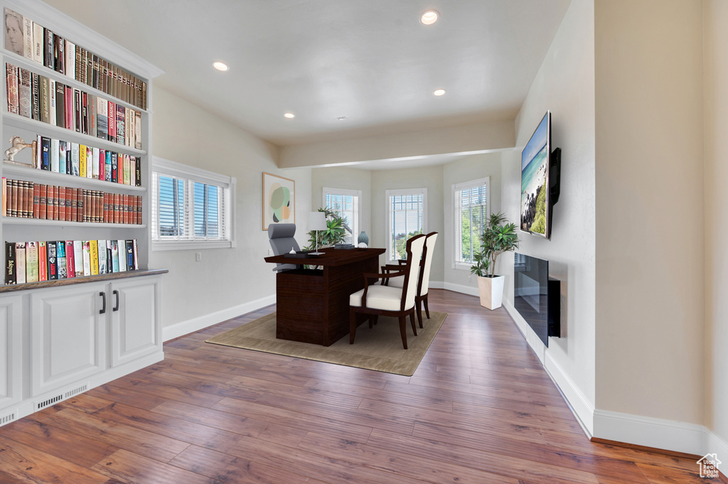 Home office with dark hardwood / wood-style flooring