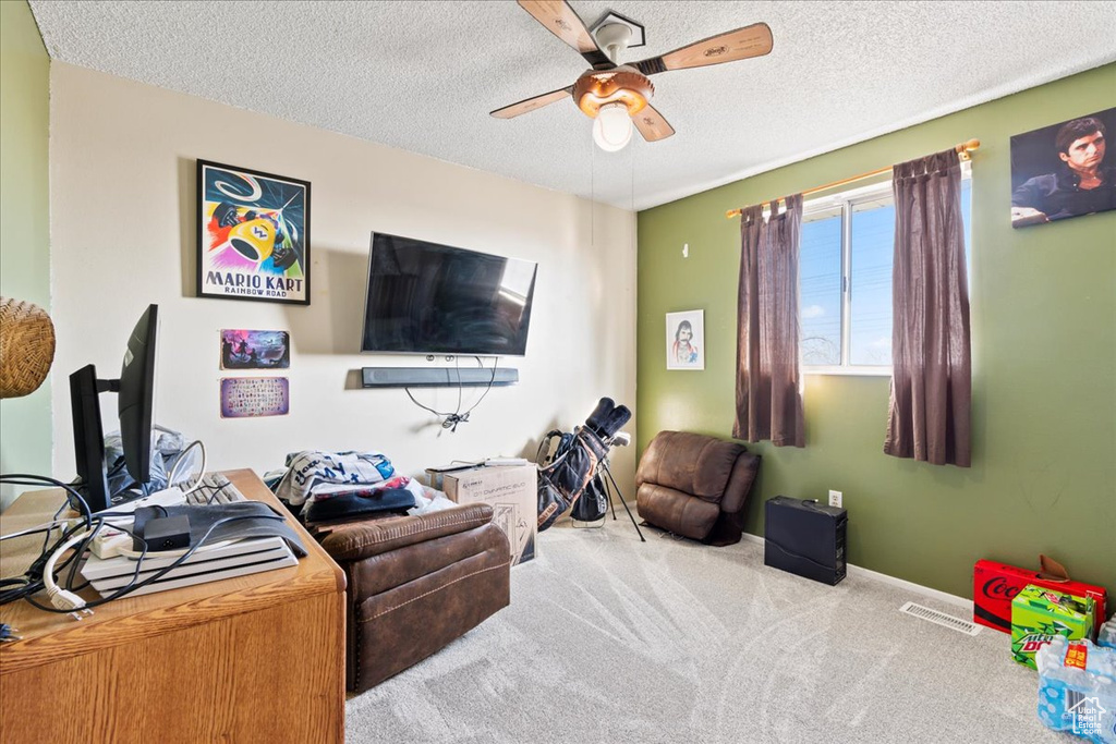 Carpeted living room featuring a textured ceiling and ceiling fan