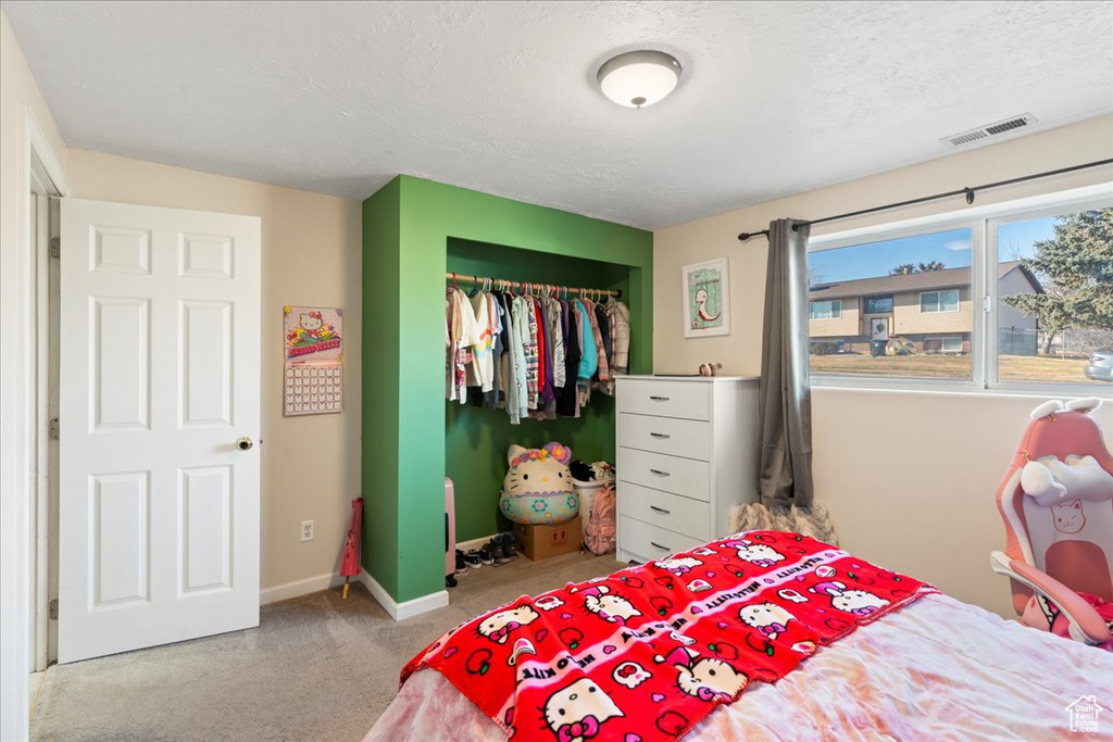 Bedroom featuring a textured ceiling and a closet