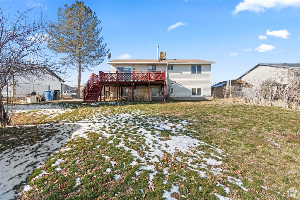 Back of property with a lawn and a deck