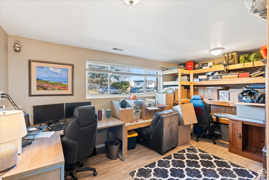 Office space with light hardwood / wood-style flooring