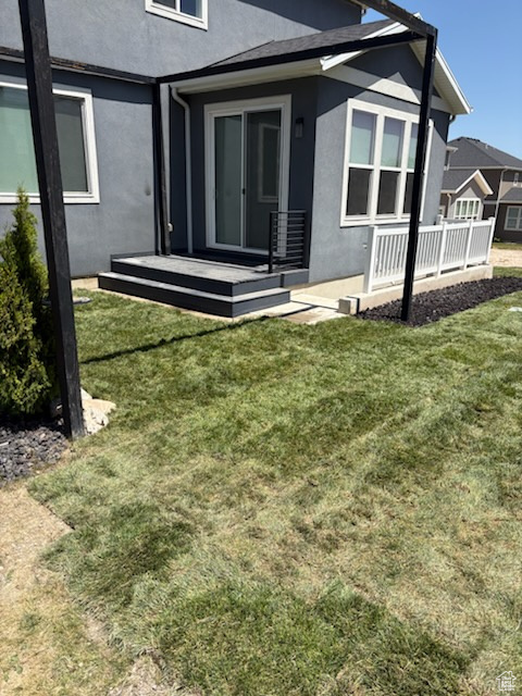 Back of property featuring stucco siding and a lawn