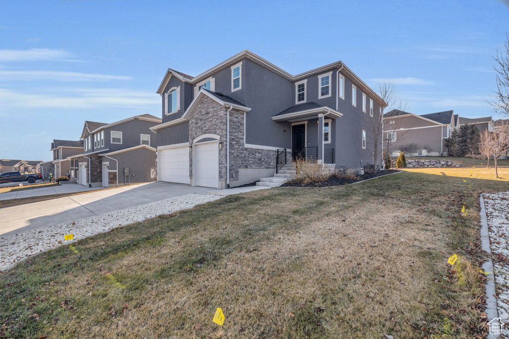 View of property with a front lawn and a garage