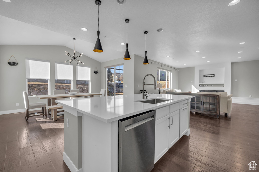 Kitchen with sink, white cabinets, dishwasher, and a kitchen island with sink