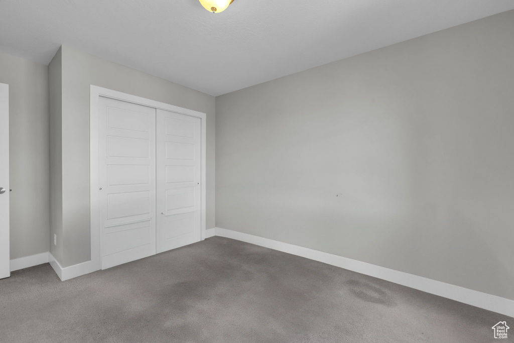 Unfurnished bedroom featuring a closet and carpet floors