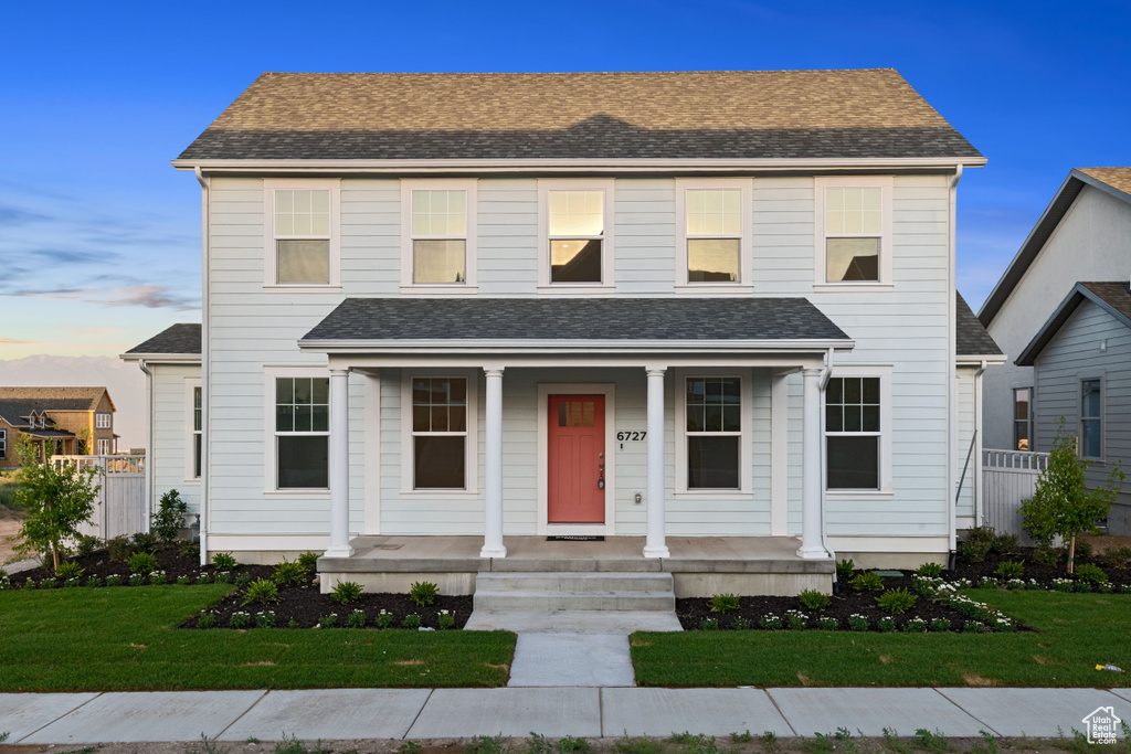 View of front of home with a porch and a lawn