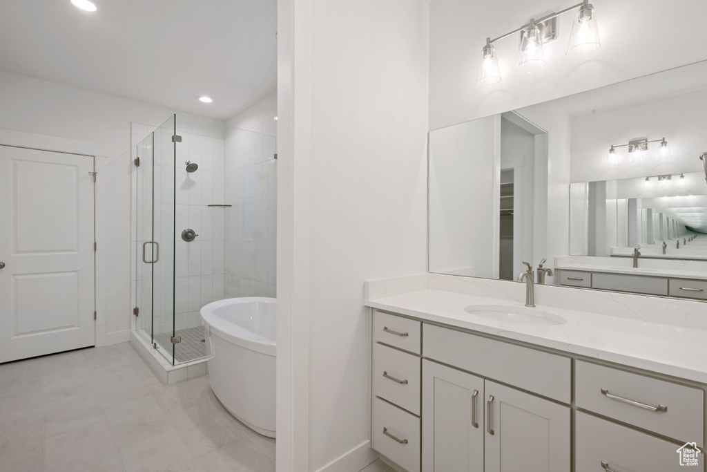 Full bathroom with a shower stall, vanity, and a freestanding bath