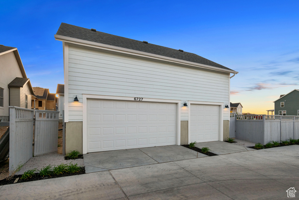 Garage at dusk with concrete driveway
