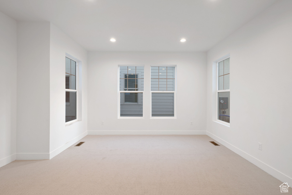 Spare room featuring light colored carpet and recessed lighting