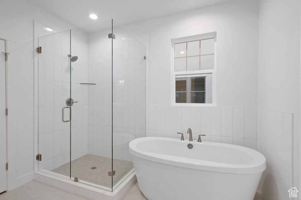 Bathroom with a stall shower, a freestanding bath, and recessed lighting