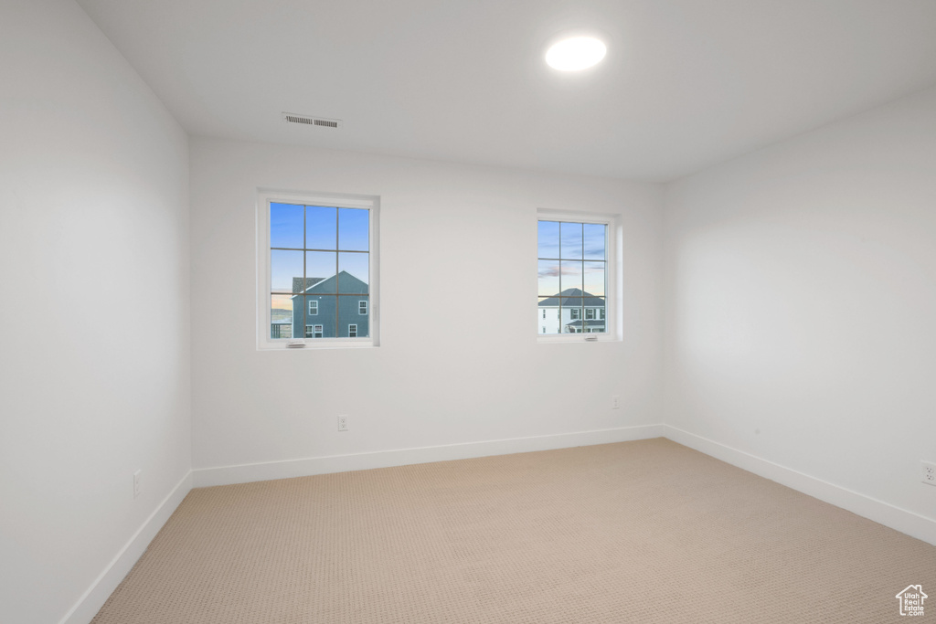 Unfurnished room featuring light colored carpet and baseboards