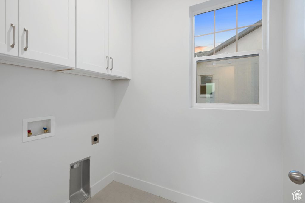 Washroom with cabinet space, electric dryer hookup, and washer hookup