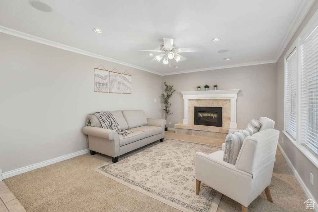 Tiled living room featuring ceiling fan, a high end fireplace, and crown molding