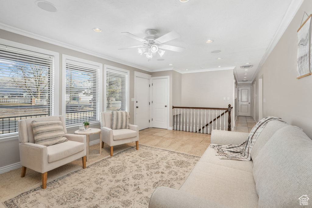 Tiled living room featuring ceiling fan and ornamental molding