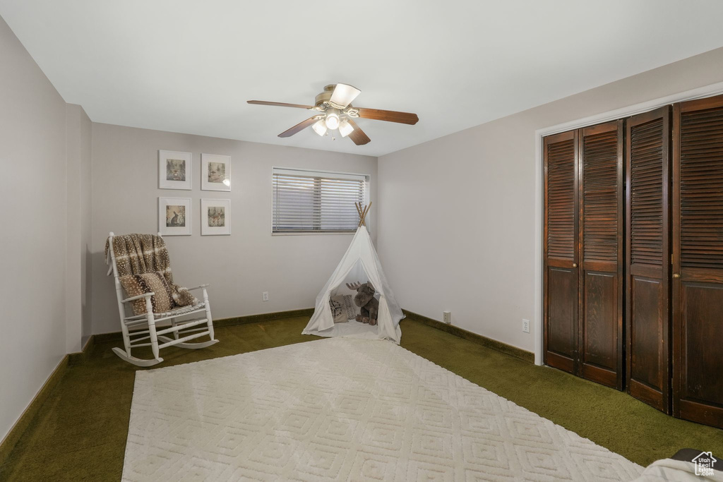Bedroom featuring ceiling fan, a closet, and dark colored carpet