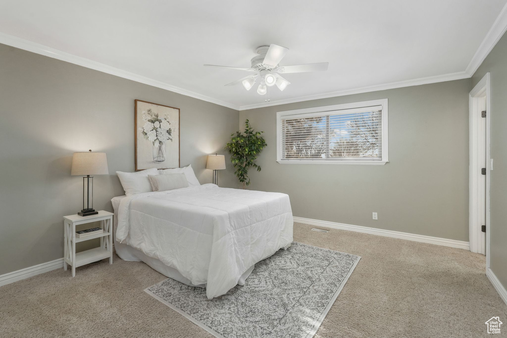 Bedroom featuring ceiling fan, carpet, and crown molding