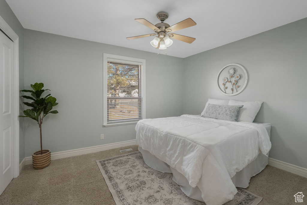 Carpeted bedroom with ceiling fan