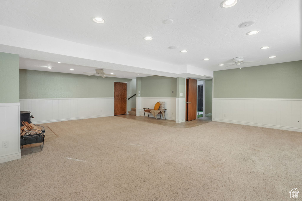 Basement featuring light carpet and ceiling fan
