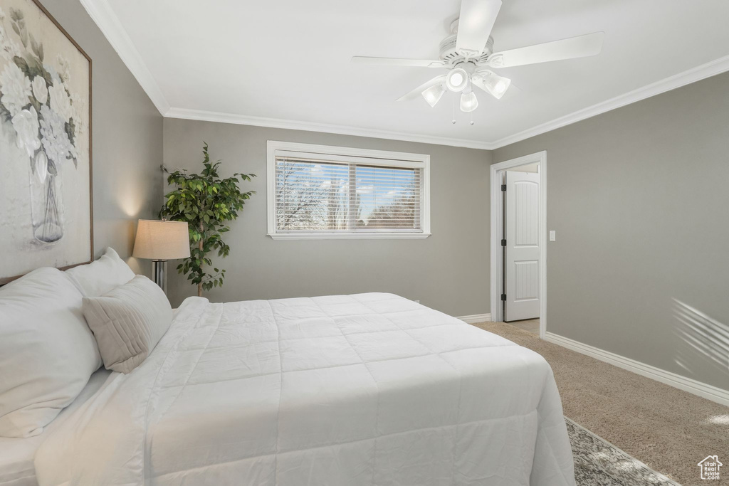 Bedroom with ceiling fan, light colored carpet, and crown molding