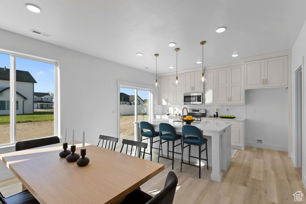 Dining room featuring light hardwood / wood-style floors and a healthy amount of sunlight