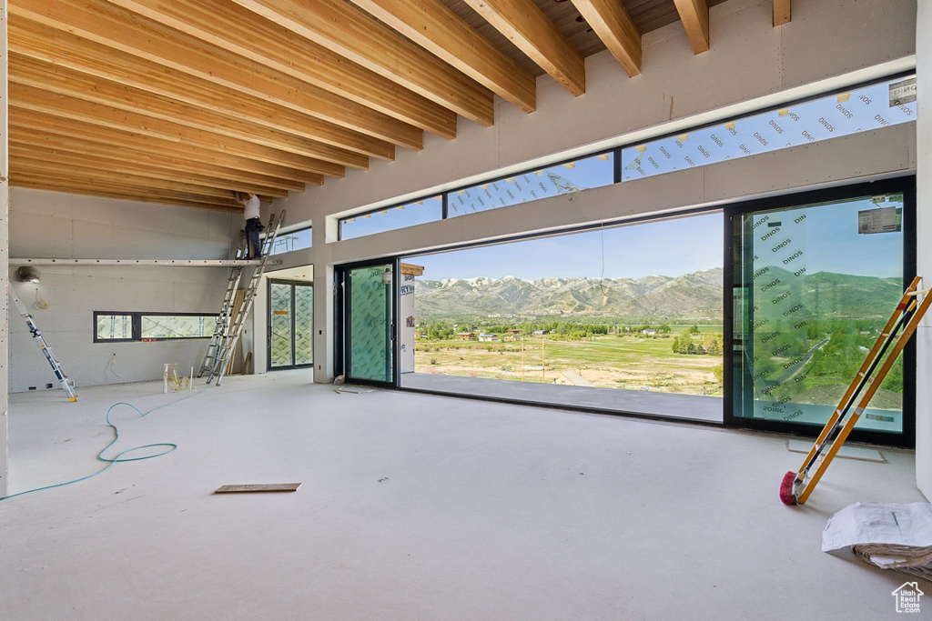 Miscellaneous room with a mountain view, beamed ceiling, and concrete flooring