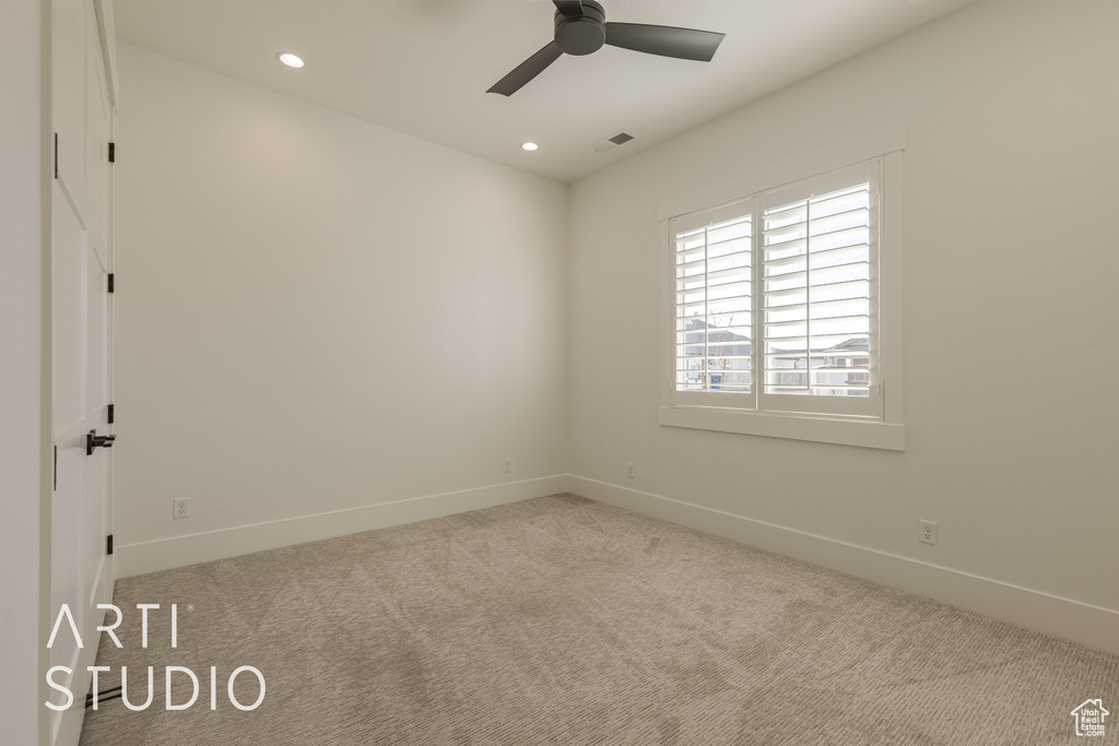 Carpeted spare room with ceiling fan