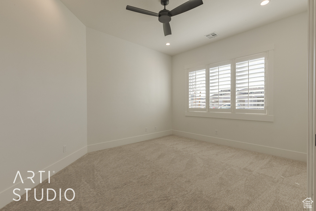 Empty room with ceiling fan and light colored carpet