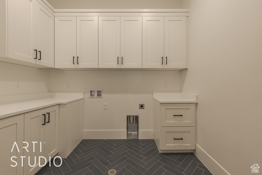 Washroom with washer hookup, cabinets, and hookup for an electric dryer