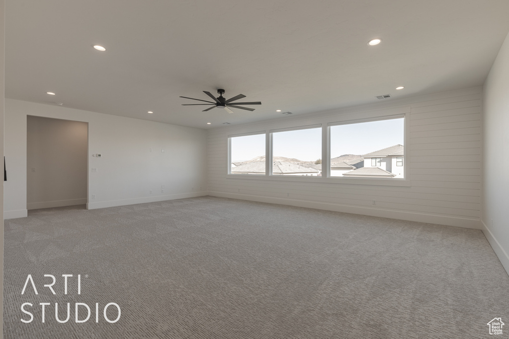 Empty room featuring ceiling fan, a mountain view, and light colored carpet