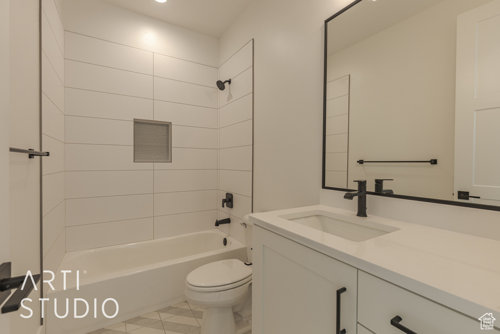 Full bathroom with toilet, tiled shower / bath, and vanity