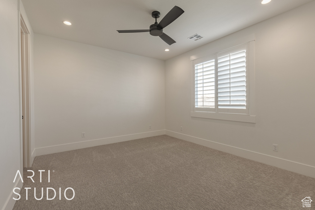 Carpeted spare room with ceiling fan