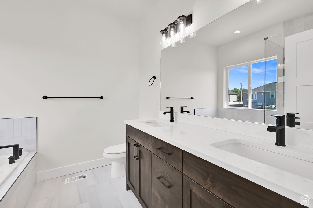 Full bath featuring visible vents, a sink, baseboards, and toilet