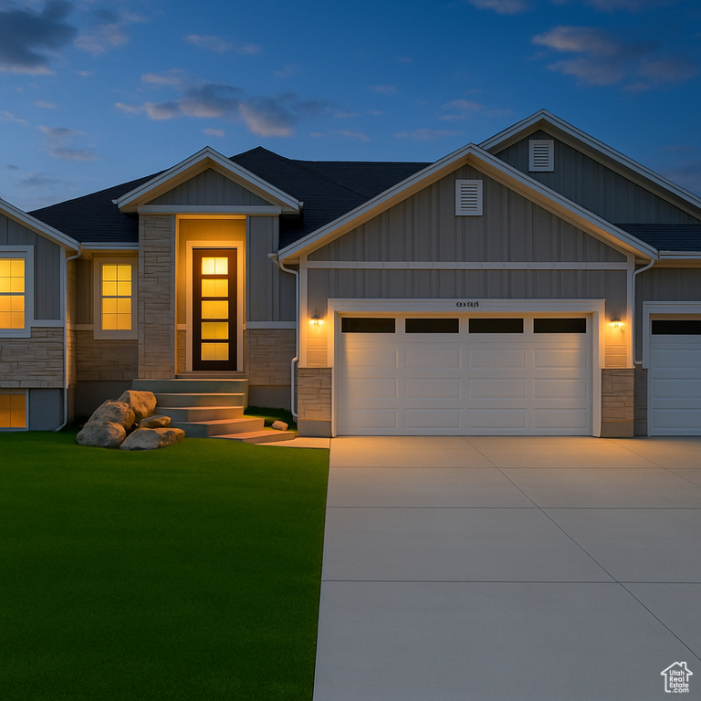 Craftsman-style home featuring a garage, board and batten siding, a front lawn, and stone siding