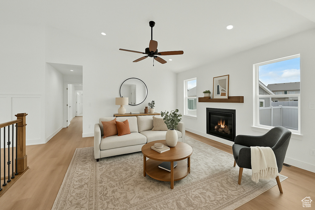 Living room featuring recessed lighting, light wood finished floors, a glass covered fireplace, and ceiling fan