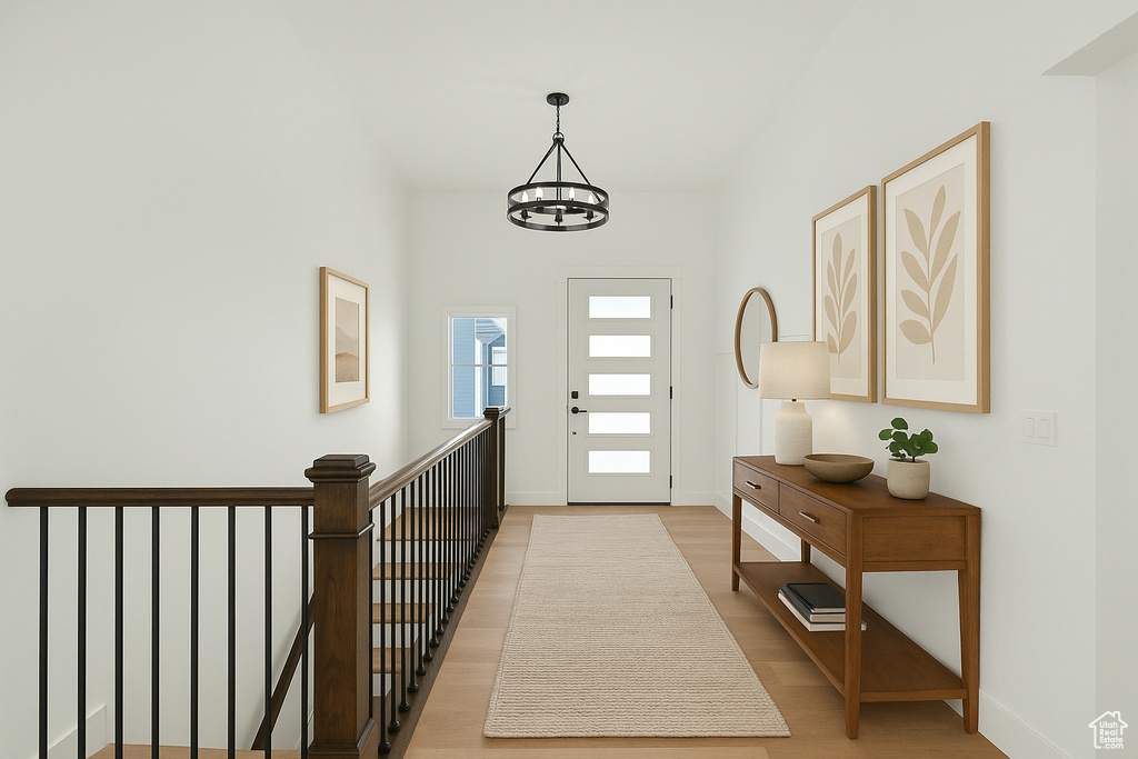 Foyer featuring baseboards, light wood-style flooring, and a chandelier
