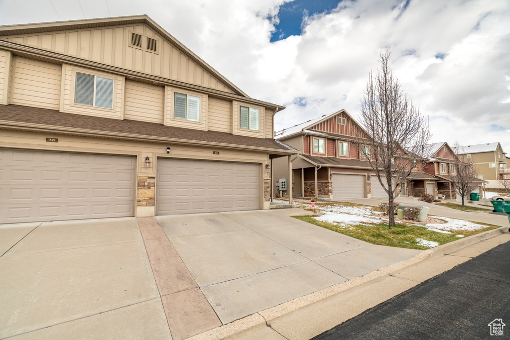 View of property featuring a garage, board and batten siding, and driveway