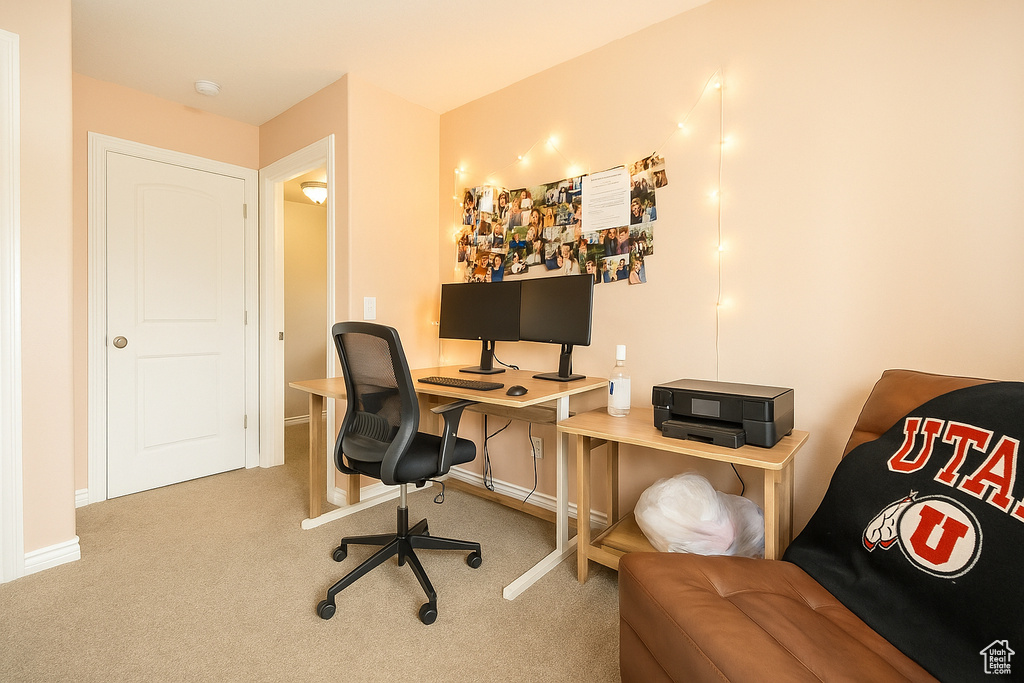 Carpeted home office featuring baseboards