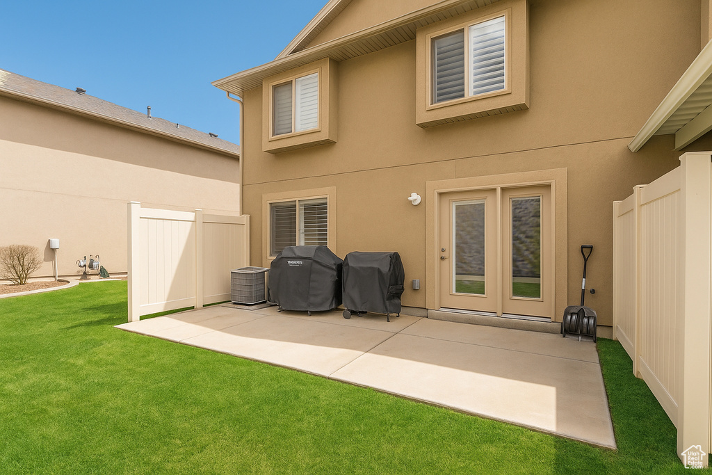 Back of property with a patio area, stucco siding, and central AC