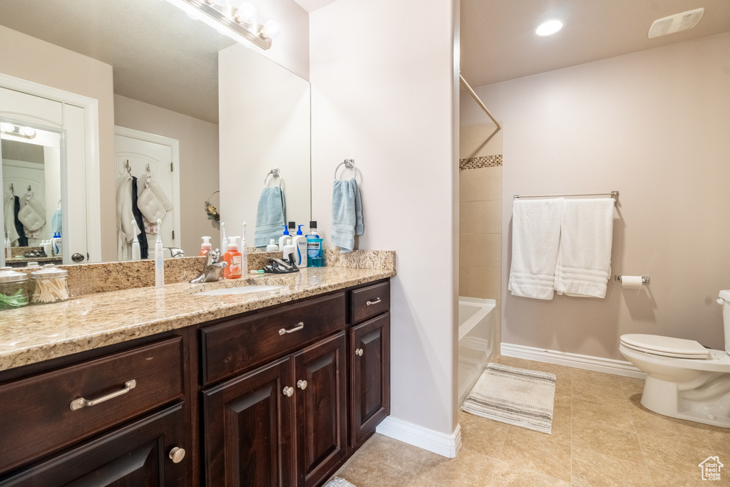 Bathroom with visible vents, toilet, shower / washtub combination, baseboards, and vanity