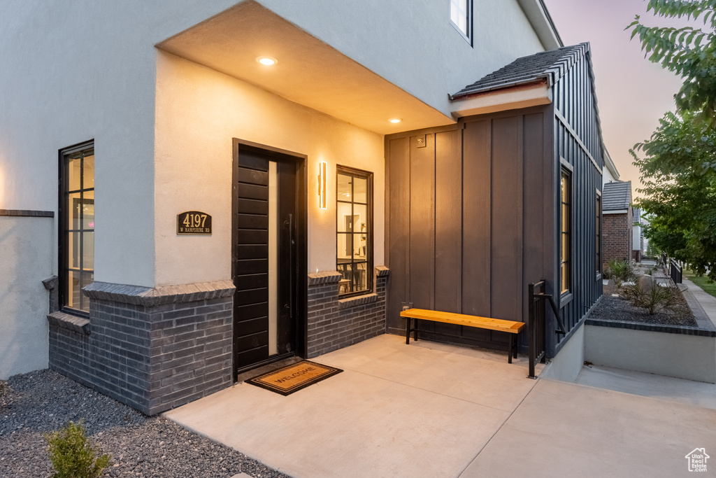 Exterior entry at dusk with a patio